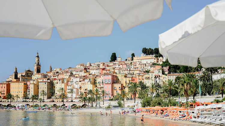 White umbrellas frame a beach scene from Menton, available as French Riviera Fine Art Prints.
