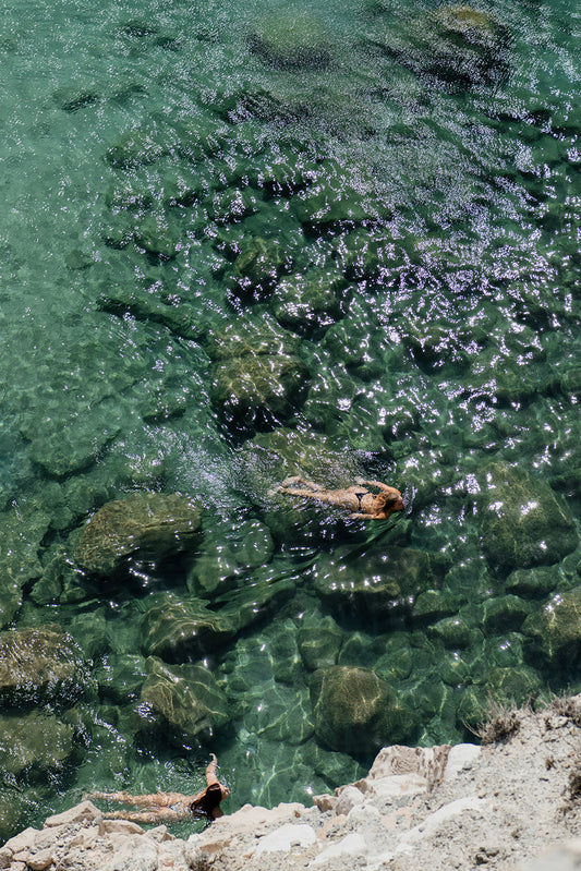 Women swimming in the ocean shot from high above. Bring vacation escapism into your home with Greece Fine Art Photographic Prints by Brooke Darling. Milos Island Mood. Greece Fine Art Prints.