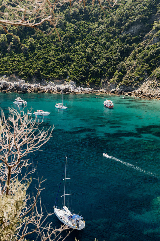 Artwork of a coastal scene with boats and greenery, exclusive to Fineprintco. Fine art travel prints are custom printed and framed to order. With premium printing and framing your investment can be enjoyed for years to come. Greece Wall Art.