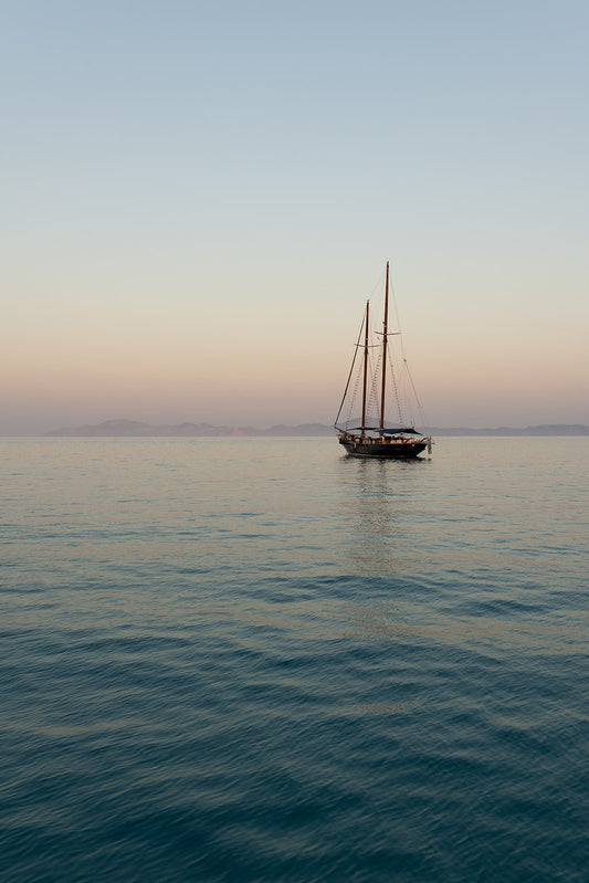 Photographic artwork of a sailboat on calm water with a gradient sky. Mediterranean Fine Art Photography Prints. Greece Wall Art, adorn your walls with sailing scenes from the Greek Islands. Sailing Art Prints.