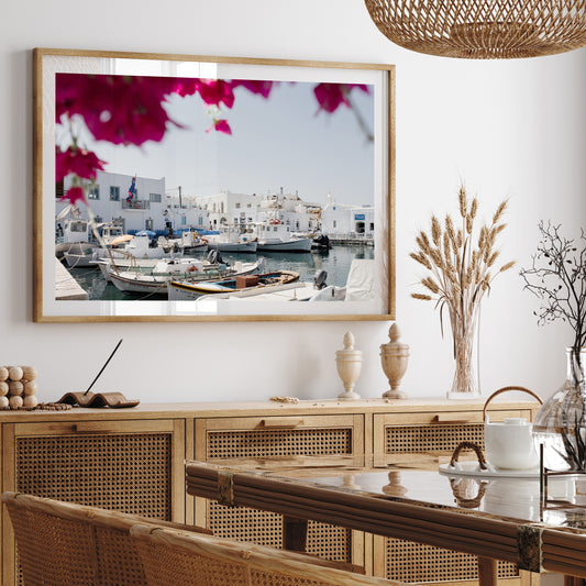 Greek Island fine art print in landscape format featuring Naoussa Boat Harbour, Paros Island with mock up in light wood frame in modern dining room.