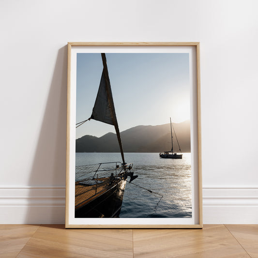 Framed photograph of sailboats on water with mountains in the background. Bring the lustre lifestyle of sailing the Mediterranean into your home with Sailing fine art prints on the sunset Dalyan Dock. Sailing Yacht Art Prints. 