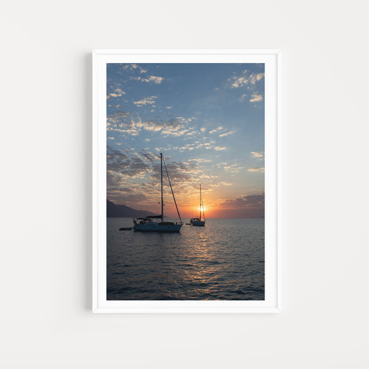 Framed photograph of two sailboats on a calm sea at sunrise with a white frame. Mediterranean Sailing Photography Art Prints.