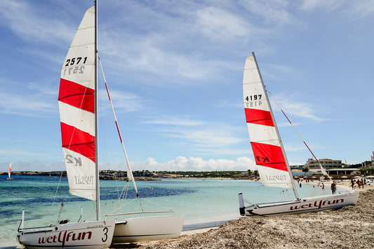 Art print photograph of two sailboats on a beach with a blue sky. SHOP FORMENTERA, BALEARIC ISLANDS, SPAIN | Balearic Islands Fine Art Prints. Bring the colour and life of summer in your home. Balearic Fine Art Prints. 