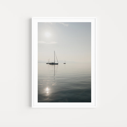 Framed artwork of a sailboat on a calm body of water with a white frame. SHOP Sailing Boat Fine Art Photographic Prints. Bring the calm of boats at anchor in your home with boats at anchor on the Aegean Sea. Sailing Wall Art.