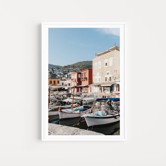 Framed photograph of a coastal scene with boats and colorful buildings. HYDRA ISLAND, GREECE SHOP Wall art prints from the celebrated Greek Island of Hydra. Fine Art Prints Hydra. Bring the classic feel of Greece into your home.