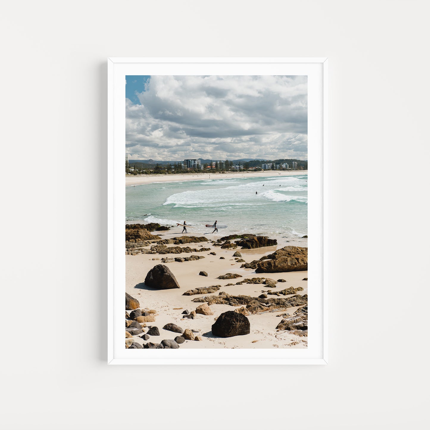 Framed photograph of a beach scene with people walking along the shore. Relive your summer memories with Australia Coastal Fine Art Photography Prints by Brooke Darling Photography. Kirra Beach Surfers Wall Art.