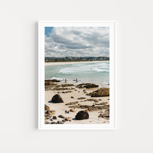 Framed photograph of a beach scene with people walking along the shore. Relive your summer memories with Australia Coastal Fine Art Photography Prints by Brooke Darling Photography. Kirra Beach Surfers Wall Art.