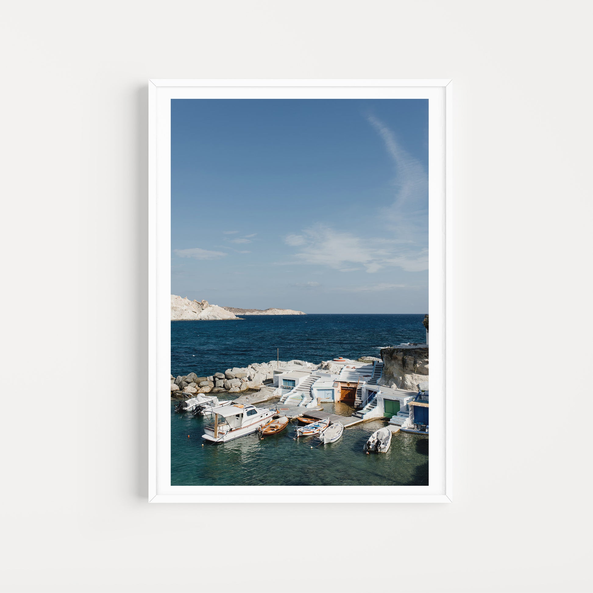 Framed photograph of a coastal scene with boats and a clear blue sky. MILOS ISLAND, CYCLADES, GREECE. SHOP Milos Fine Art Photography Prints. Bring summer love and vibes into your home with Milos Framed Wall Art. 