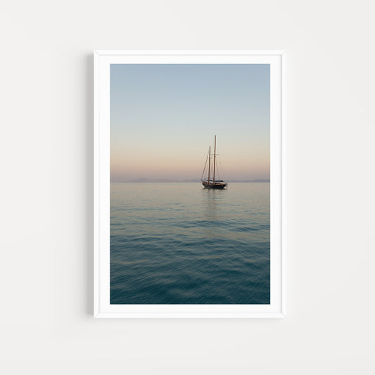 Framed artwork of a sailboat on calm water with a gradient sky. Mediterranean Fine Art Photography Prints. Greece Wall Art, adorn your walls with sailing scenes from the Greek Islands. Sailing Art Prints.