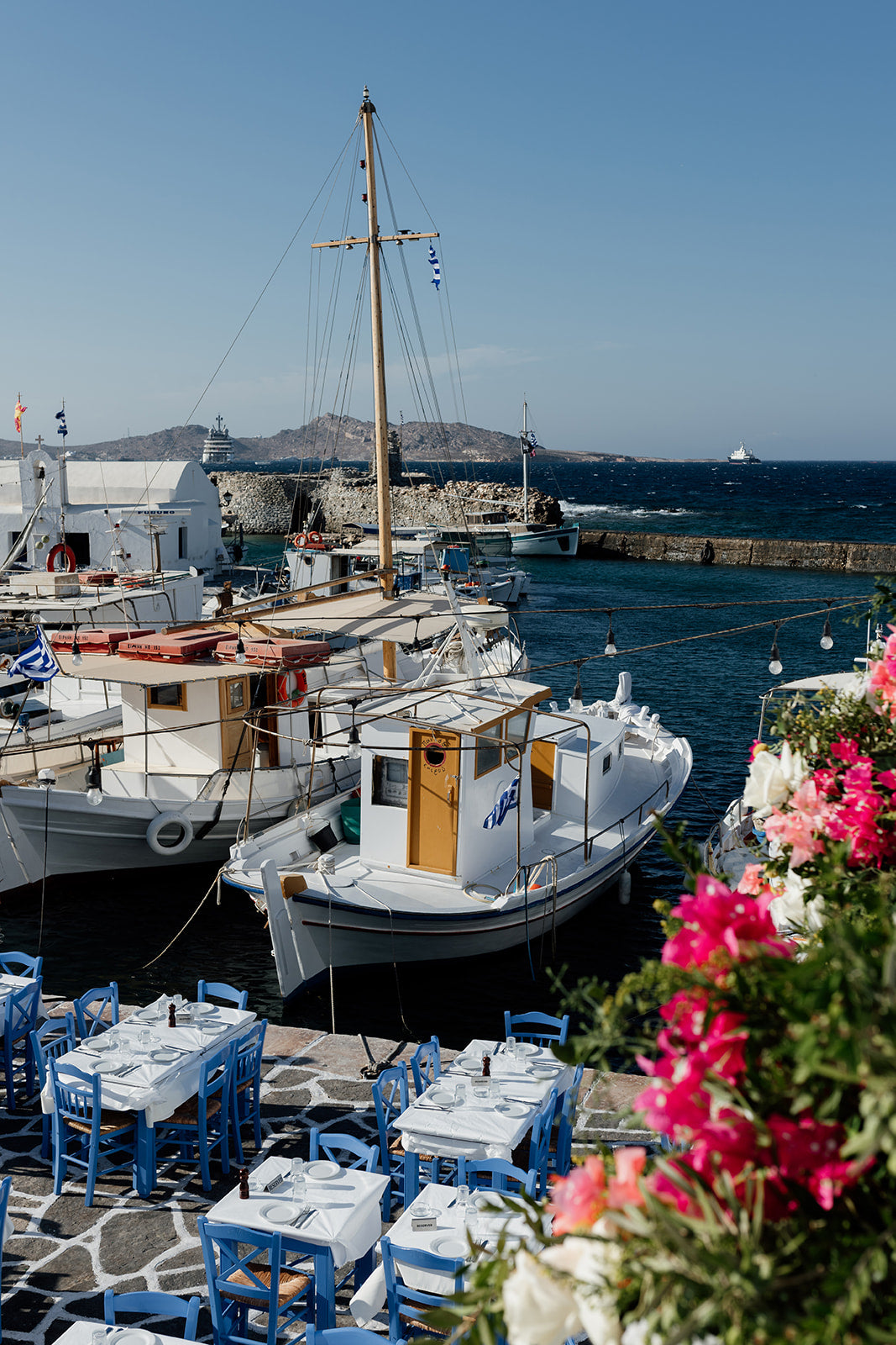 Boat and tables at the famous Naoussa Boat Harbour on Paros Island available at Greece fine art prints for your walls. 
