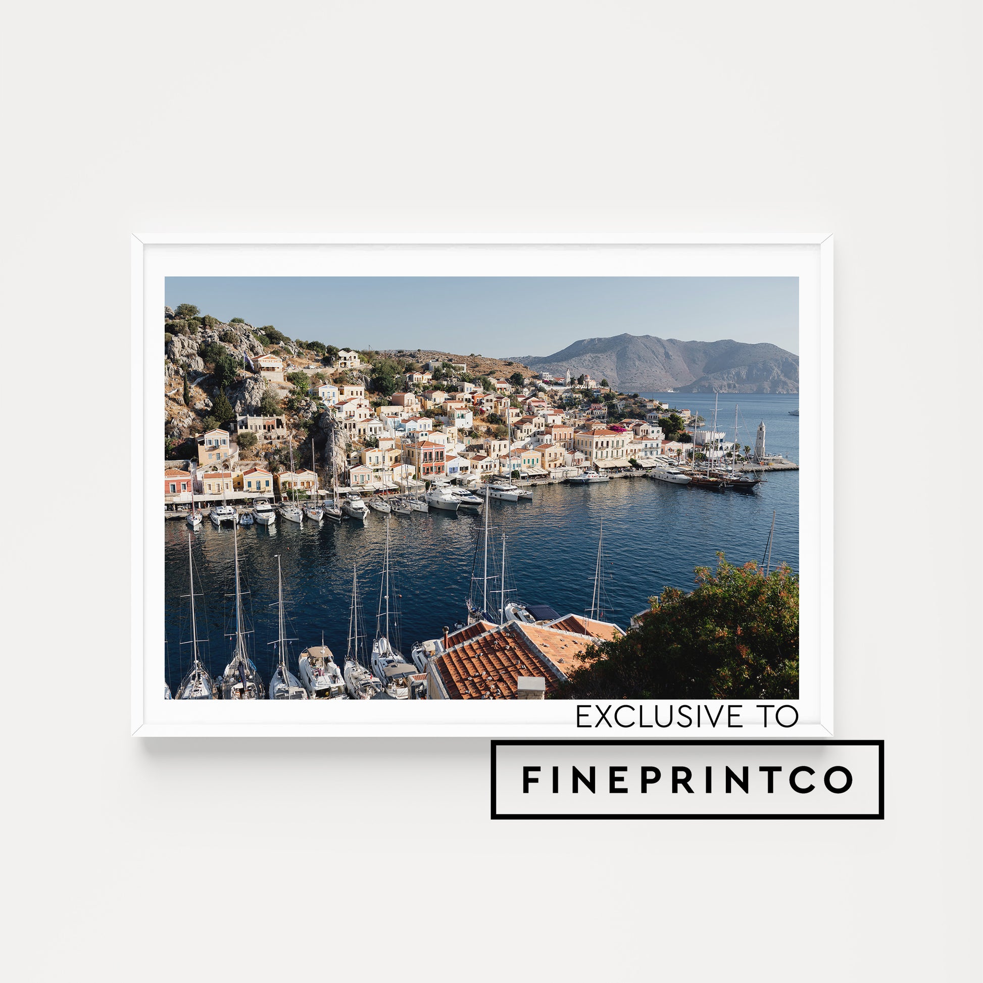Framed photograph of a coastal town with boats docked in a harbour. SHOP HERE. SYMI, DODECANESE ISLANDS, GREECE | Symi Island Wall Art Prints, custom made to order. Bring Greece art into your home. Symi Island Wall Art.