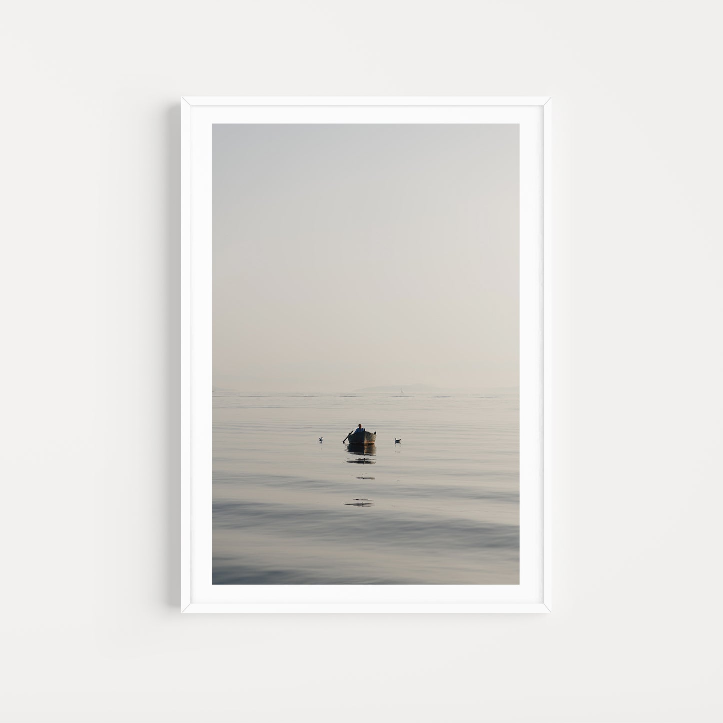 Framed artwork of a small boat on a calm body of water with a white frame. SHOP Mediterranean Wall Art Prints | Browse artfully captured and curated range of wall art and scenes from the Mediterranean. Mediterranean Fine Art Prints. 