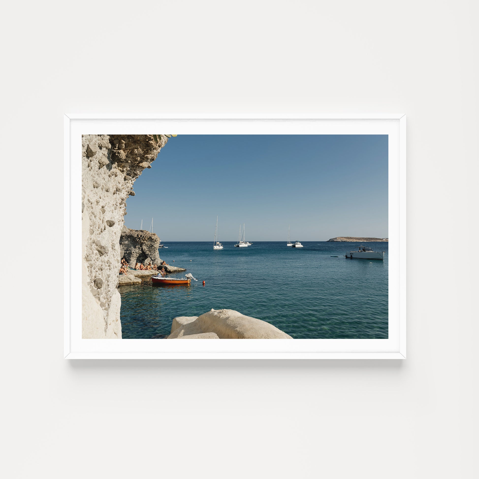 Framed photograph of a coastal scene with boats and cliffs. KIMOLOS ISLAND, CYCLADES, GREECE. SHOP Mediterranean Fine Art Prints with summer kissed scenes from Kimolos Island. Mediterranean Wall Art.