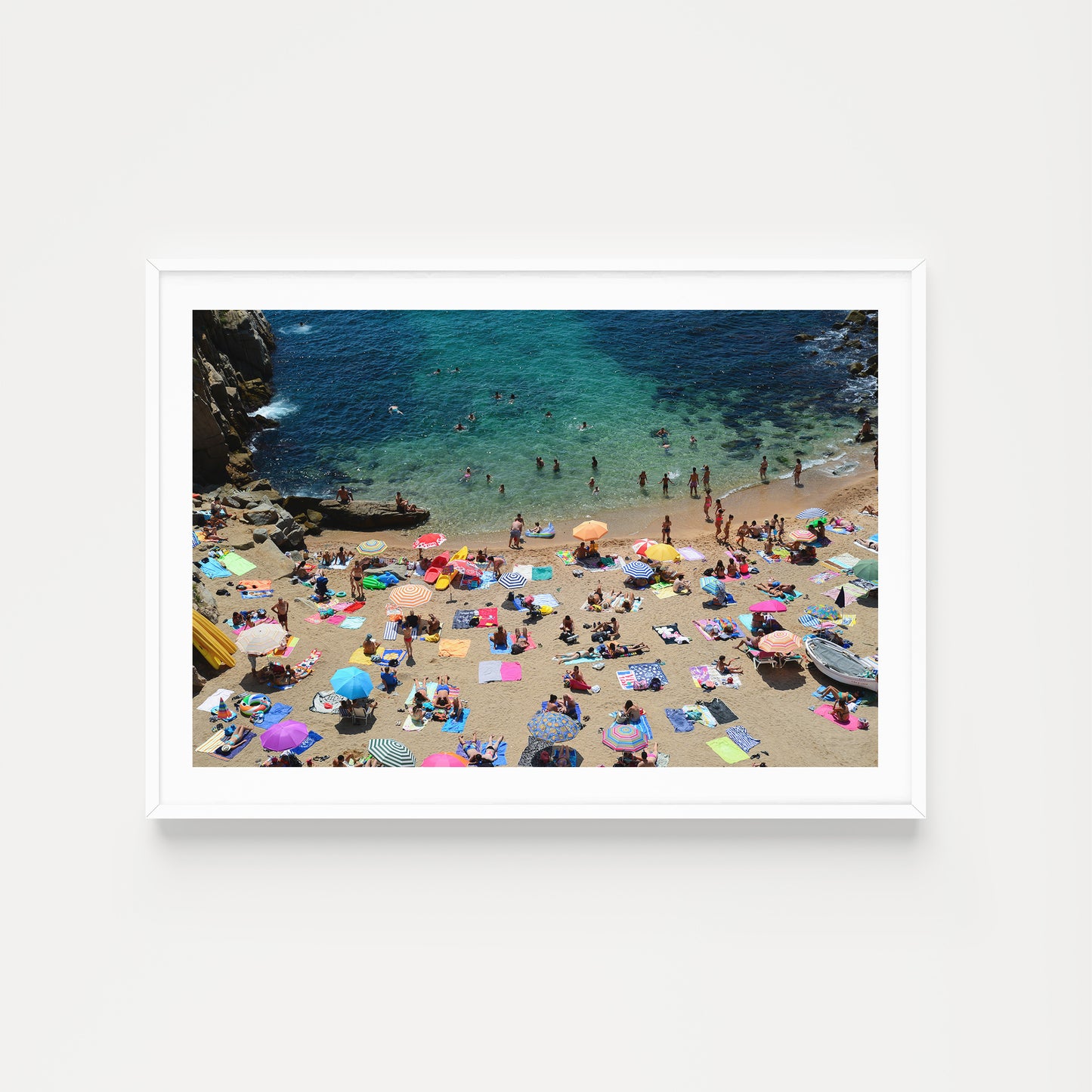 Beach scene with people and colorful umbrellas on a sandy shore with clear blue water. Buy Spain photographic prints in limited edition from Brooke Darling's exclusive collection. Coastal Spain fine art photography prints. Spain Wall Art.